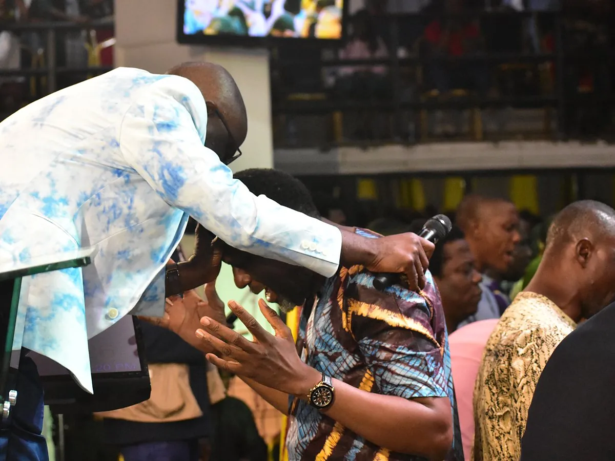 A minister laying hands on members as they pray